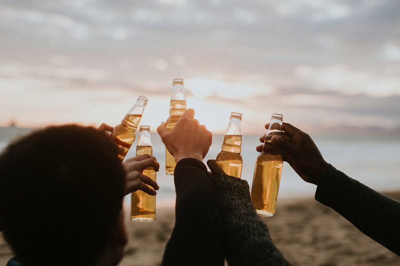 Group of friends cheers beers.